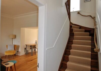 The wooden staircase leads to a contemporary family bathroom on the first floor and the two spacious bedrooms