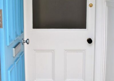 Blue front door with doormat saying Hello