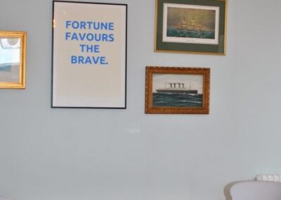 Framed poster above dining table reads Fortune Favours the Brave