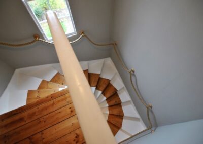 Staircase curves down clockwise with rope bannister