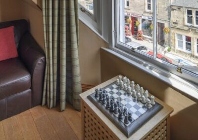 Chess set on small table in front of window looking down towards the Crail High Street