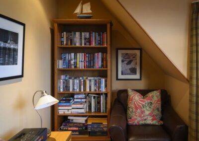Bookcase filled with books next to a leather armchair