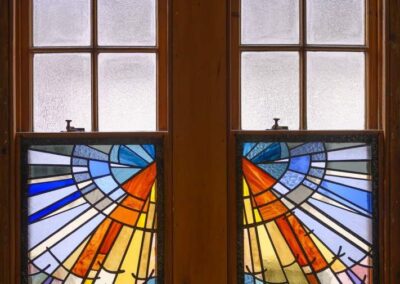Stained glass window showing coloured light coming down from the sky