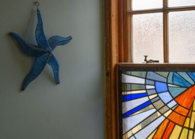 Blue starfish decoration next to stained glass window