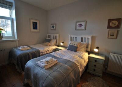Twin single beds with white wooden headboards .