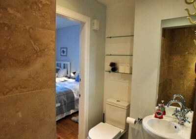 View from interior of shower room looking towards bedroom through an open door