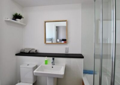 White suite with bath and transparent shower screen