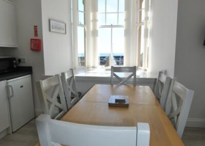 View across dining table towards bay window. Kitchen is on the left.