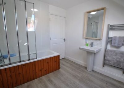 Family bathroom has a large, chrome towel rail to the right of the sink