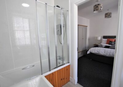 Bedroom 3 has an en-suite bathroom with a shower over the bath