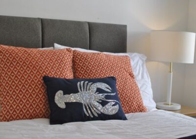 Lobster design on a dark blue pillow on the bed