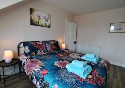 Double bed with floral linen bedside tables and lamps either side