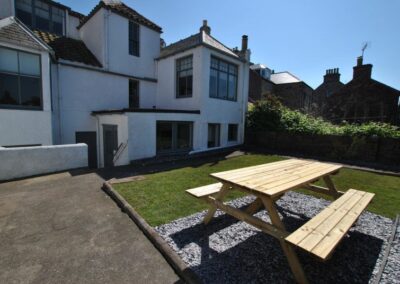 View across wooden picnic table towards the house