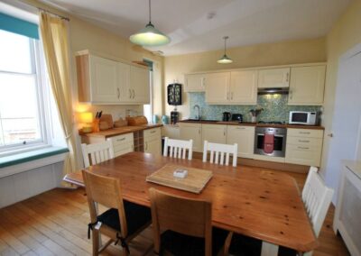 Wooden dining table set for six in kitchen.