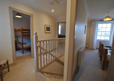 Top of the staircase with doors to bedrooms.