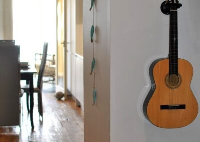 A Spanish guitar hangs on the wall to the right of a small passage to the dining kitchen.