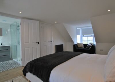 View from left of the bed towards the en-suite on the left and seating area on the right.