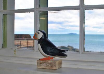 Puffin ornament on a window looking towards the Isle of May.