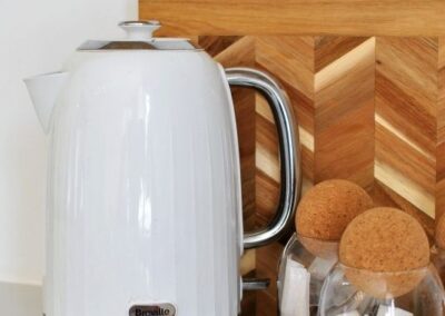 Electric kettle with a jar of tea bags and a jar of sugar.