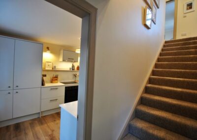 Open door to the kitchen on the left. On the right, stairs up to the bedrooms.