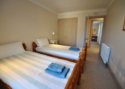 Two single beds, side by side. Perpendicular to the door to the corridor.