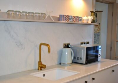 Sink, kettle and microwave on the kitchen counter.
