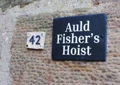 Two signs on a stone wall: 42 and Auld Fisher's Hoist