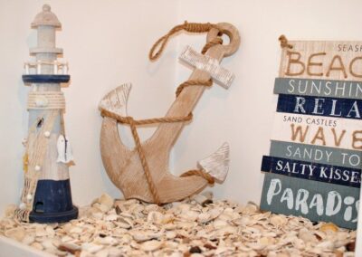 Wooden ornaments of a lighthouse, anchor and sign.