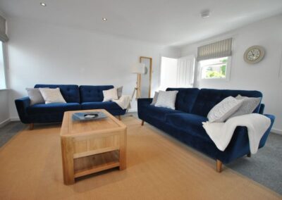 Blue sofas at right angles around a wooden coffee table.