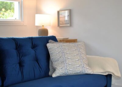 Close-up of blue sofa with white and blue fish-design cushions.