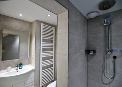 Walk-in shower with tiled walls.