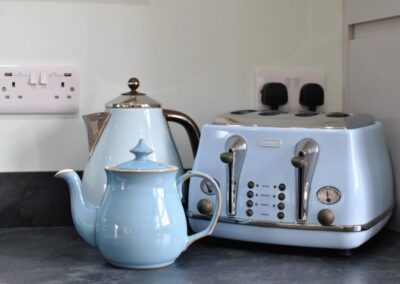 Details of blue kettle, teapot and toaster.