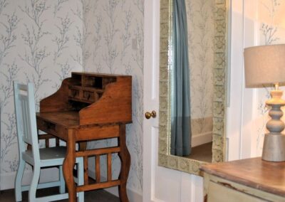 Writing desk in corner with wooden chair