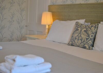 Close up of bed with luxurious cushions and towels.