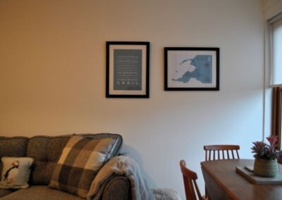 Modern framed images on the wall behind the sofa.
