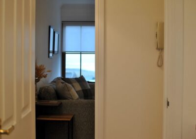 View from hallway into lounge. There is an entry phone on the wall.