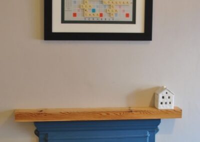 Framed Scrabble board picture above fireplace.