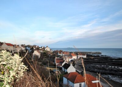 View across red roofs towards the pier and sea
