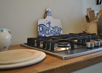 Close-up of gas hob with chopping board beneath with a sea design that reads Choppy Today.