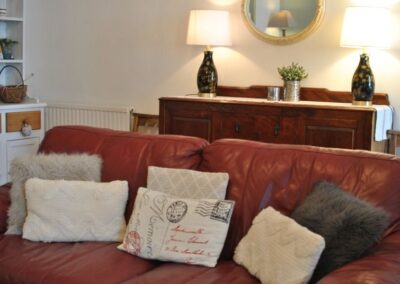Red leather sofa with a variety of cushions.