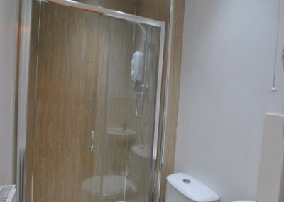 Walk-in shower with white bathroom suite.