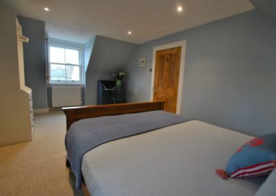The bedroom is decorated in a variety of blues and shades of white.