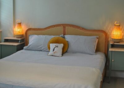 Close up of bed with stylish lamps either side.