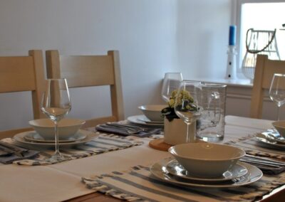 Close-up of crockery, cutlery and glasses on dining table.