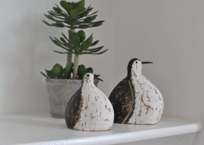 Potted plant with two wooden bird ornaments.
