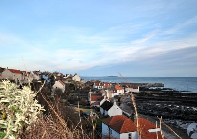 View across red roofs towards the pier and sea