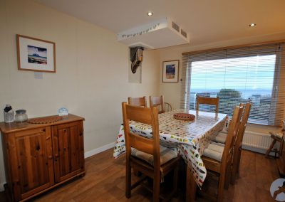 Dining table set for six in front of large window with Venetian blinds
