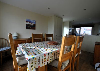 Table with fish-design table cover with six wooden chairs.
