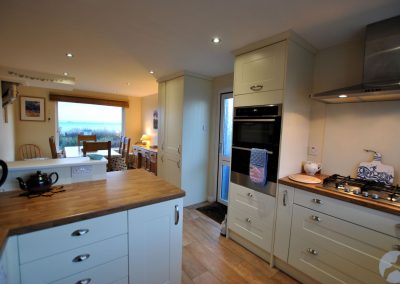 Oven above drawers to the left of a gas hob.