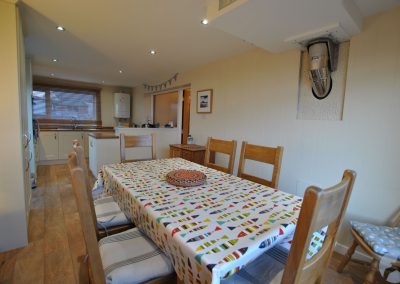 View from behind dining table towards kitchen.